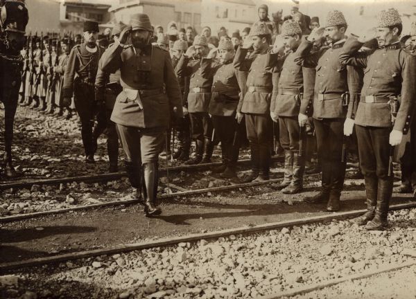 Troops saluting Djemal Pascha as he is walking inspecting them as they move to the front. 