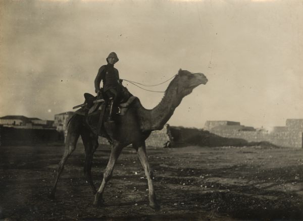 German officer, riding a camel, on patrol in the desert. 