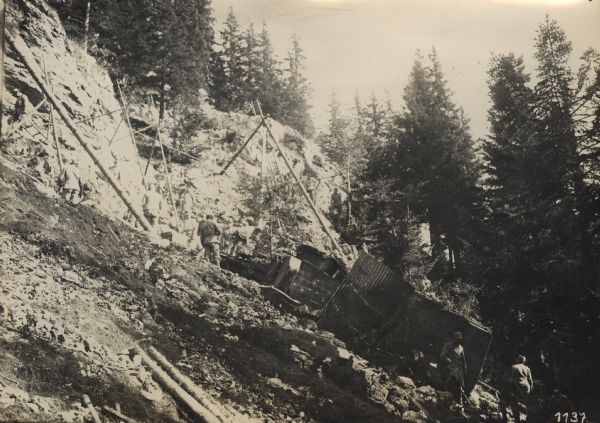 Both good and bad luck at the same time. While driving passed an artillery shell damaged section of a mountain road, a heavily loaded supply truck slid off into a ditch. However, the driver was unhurt.  Soldiers are using a crane to lift the truck. 