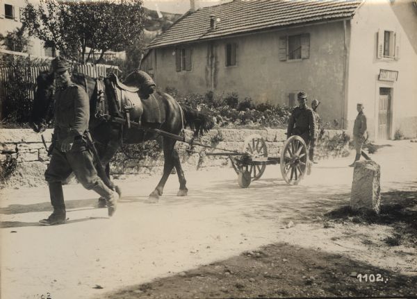 Soldiers and horse-drawn wagons moving to the front. 