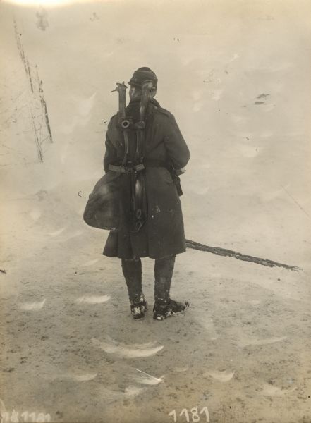 A soldier on the Ortler (Mount Ortles) carrying a machinegun base and legs on his back. 