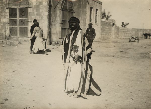 A Senussi fighter walking in the middle of the street. 