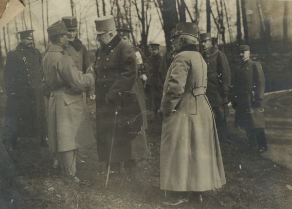 The visit of the Czar of Bulgaria to the Austrian headquarters. The Czar is decorating an Austrian corporal who single-handedly held a fighting position in the Carpathians for five hours against enemy attack. He is being given the Golden medal for Bravery along with a Bulgarian decoration. The czar is in the middle of the image. Archduke Frederick is on the right. 