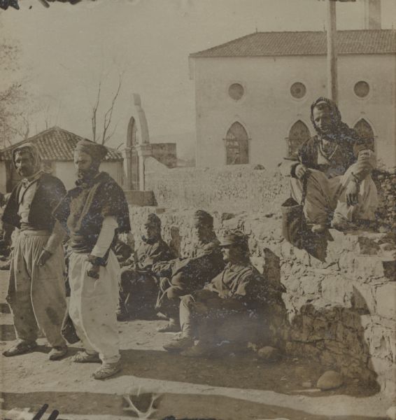 Albanian volunteers, in front of a barracks, offering to serve as guides. 