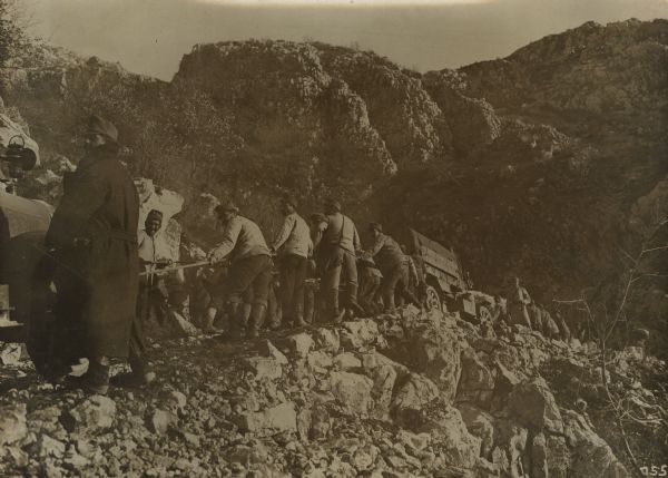 Repair work on Mount Lovcen to repair war damage caused by the Montenegrins. Vehicles are being pulled up a detour path on the mountain.