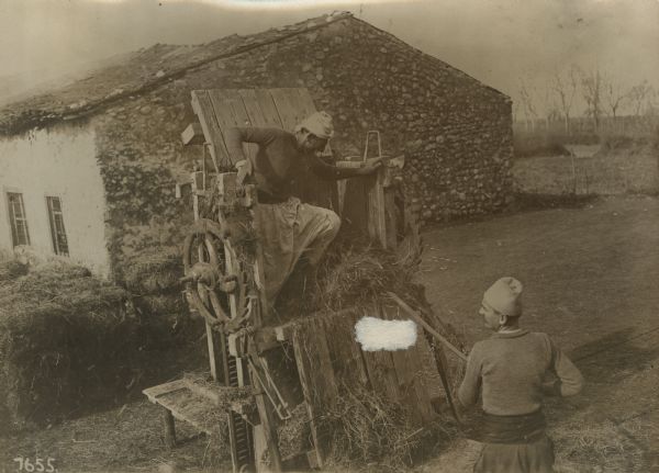 Albanian farmers baling hay under Austrian supervision.