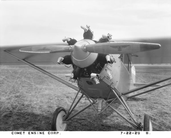 Close-up view of the front of a Sierra BLW-2 aircraft, fitted with a Comet 7-RA air-cooled radial piston engine and a wooden Westinghouse Micarta propeller. The wings and wheels, along with respective struts, are also visible. The 7-RA engine, originally designed by the Comet Engine Corporation in 1928, was manufactured on a Gisholt turret lathe in Madison, Wisconsin, and briefly used on the Sierra line in 1929. Built by Sierra Aircraft Industries which was established in 1928, this BLW-2 was intended for a new aviation school and air-taxi-service based in San Leandro and Modesto, California; the aircraft company ended operations in 1930. The BLW-2 measured 25 ft. 8 in. in length, had a 36 ft. wingspan, and was powered by a 7-RA Comet engine running at 130 hp and 1825rpm.

The plane, with registration number X7713, is parked on a landing field. Decal text on the nose reads: "Powered with Comet Aviator Motor." The propeller blades show the Westinghouse manufacturer logo "W" centered in a circle with wings and the words "MICARTA PROPELLER."