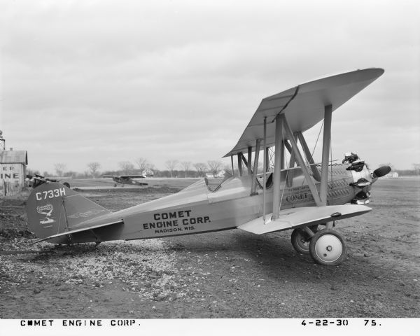 Right side profile view of an Alexander Eaglerock A-12 aircraft fitted with a Comet 7-RA air-cooled radial piston engine. A model of the Comet Engine Corporation, the engine was manufactured on a Gisholt turret lathe in Madison, Wisconsin. The plane was designed in 1929 by Alexander Aircraft Company of Engelwood, Colorado, a company originally formed in the 1925 by J. Don Alexander. Between 1928 and 1929, Alexander Aircraft company was the world's largest aircraft manufacturer. The A-12 was a two-seat bi-plane airplane that measured 25 ft 11 in length with a 36 ft 8 in wingspan and was powered by a 7-cylinder Comet engine running at 130 hp. The Alexander Aircraft Company later refitted a few A-12 models with the 7-E Comet engine, running at a faster speed of 165 hp. 

Gisholt Machine Company purchased the Comet Engine Corporation in 1929, and moved the Comet factory from Oakland, California to Madison, Wisconsin. The plane is parked on an airstrip presumably at a hanger in Madison and was used for corporate advertising. Its registration number is X733H and decal text on the tail reads: "Alexander Eaglerock" and "Alexander Aircraft Co." The plane body by the cockpit reads: "Tie your ship to a Comet." 