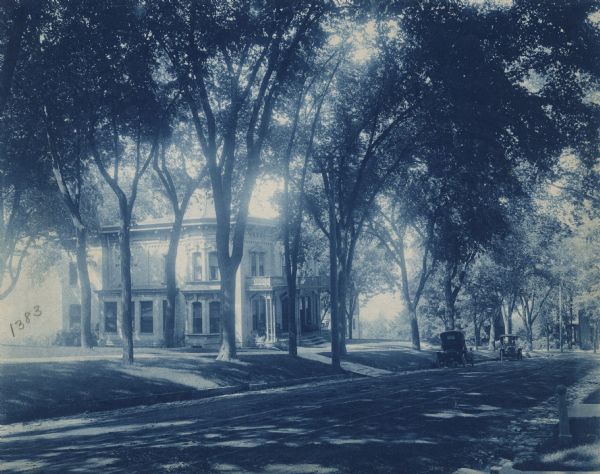 Residence of Carl A. Johnson, a Madison industrialist and president of the Gisholt Machine Company. Located at 142 East Gilman Street, Johnson occupied the dwelling from 1900-1927, when he added a square bay side to the first floor and rear wings. The home was built by Benjamin Franklin Hopkins. The photograph was made by "J.H.N." 