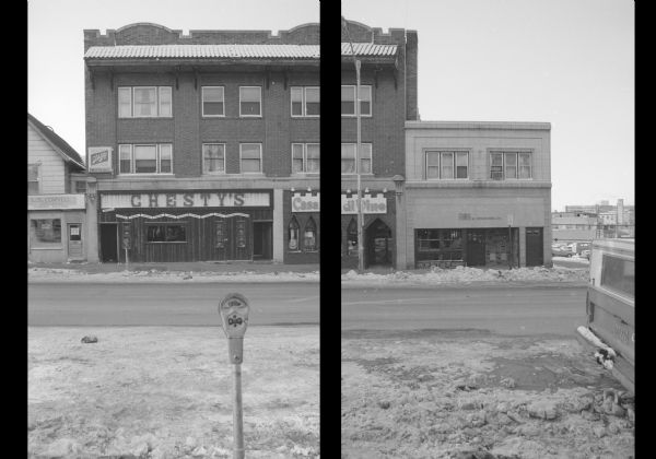 View across State Street towards two buildings. The one on the left is the Schmitt and DeLonge Building, and on the ground floor is Chesty's (left), and Casa di Vino (right). The building on the right is a two-story commercial building, Furs by Hershleder, Ltd. To the left of Chesty's is L.S. Coryell, Jeweler. To the right of Furs by Hershleder, Ltd. is an empty lot. There is a parking meter in the foreground.