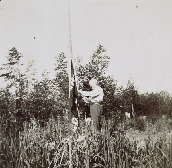 I.P. Rumsey is raising the Island Lodge flag. Caption reads: "Up with the flag! I.P. Rumsey."