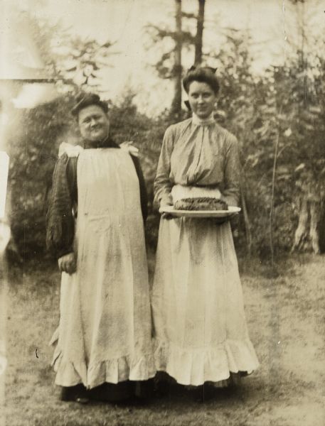 This a portrait of the Island Lodge cook Mrs. Schauers (left) and another household employee displaying a fine culinary work of art: a shortcake topped with berries. 