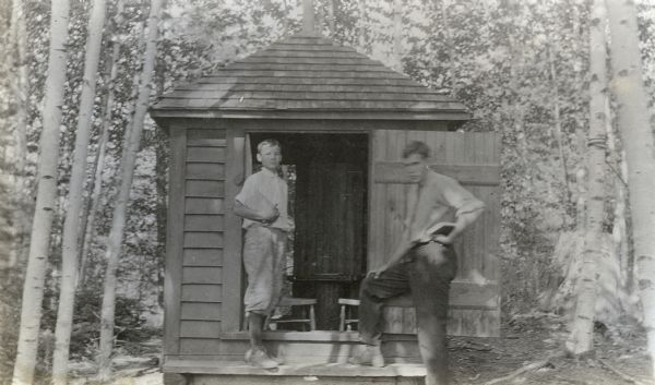 From left to right, Donald Holt and Donald Bridgeman, each holding a book, are standing in front of the Cupola on the Island. Caption reads: "Donald, Donald Bridgeman."