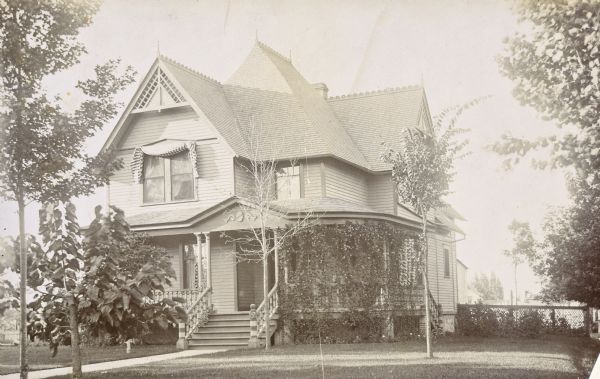 Front view of the two-story Queen Anne style home where Lucy and W.A. Holt lived together after their marriage in 1895. The address is 523 Main Street, Oconto, Wisconsin.

"A front veranda with thin doubled Tuscan columns wraps around the east side of the house and shelters a double doorway. The steeply pitched gables of the roof are trimmed with large geometrically-designed bargeboards and the chimney stack pierces the roofline."  (Source: Wisconsin Historical Society Architecture and History Inventory. Search on Ira Brooks Pendelton House or reference no. 23327.)

Caption reads: "Home Sweet Home Oconto 1897."