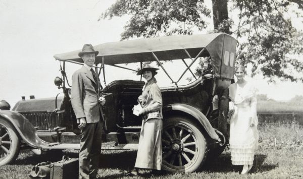 After their wedding, Ethel and Werner Duecker are preparing to depart in an automobile. Maid of Honor Jeannette Holt is standing on the right.