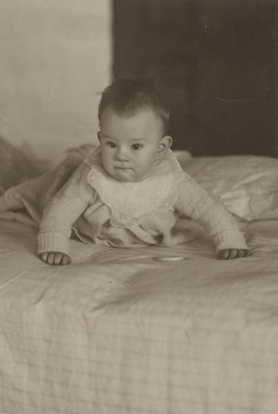 This portrait is of either Arthur Wheeler Holt (b. 5-15-1921) or Barbara Ellen Holt (b. 8-12-1923). The child appears to be crawling with head up and arms stretched out. 