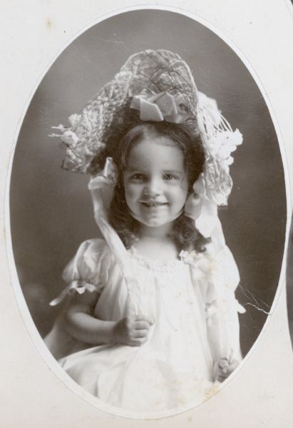 Studio portrait of Mary Eleanor Holt. She is smiling and wearing a big hat. Caption reads: "Mary Eleanor. 3 years. 1903."