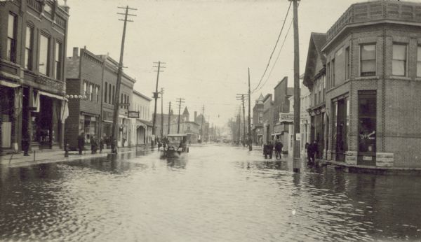 A view of a car coming down Main Street during the flood of March 1920. Caption reads: "Main St."