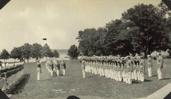 A group of students are marching into the hall at Northwest Military and Naval Academy on the south shore of Lake Geneva. Page caption reads: "Donald's Commencement NWMA." Photograph caption reads: "Class marching into the hall."
