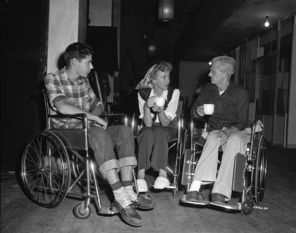 Director Ida Lupino with two men on the set of her 1949 film "Never Fear." All three are in wheelchairs.