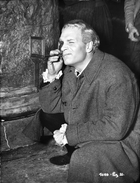 Director and actor Laurence Olivier looking through a device on the set of the 1949 film "Hamlet." The device appears to provide a literal frame for the viewer to use when planning shots. 