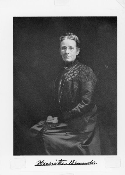 A copy of a seated, three-quarter length studio portrait of Henriette Brandhorst Brumder (1841-1924). She is wearing a dark dress with embroidered trim, a long necklace and brooch. Her hair is braided. A native of Hille, North Rhine-Westphalia, Germany, Henriette Brandhorst immigrated to Milwaukee in 1853 and married George Brumder in 1864.  