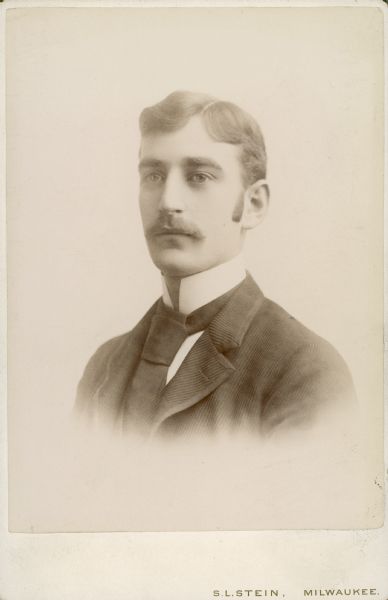 Head and shoulders studio portrait of William C. Brumder (1868-1929), eldest son of George and Henriette Brandhorst Brumder. He is wearing a suitcoat, tie and high collared shirt.  