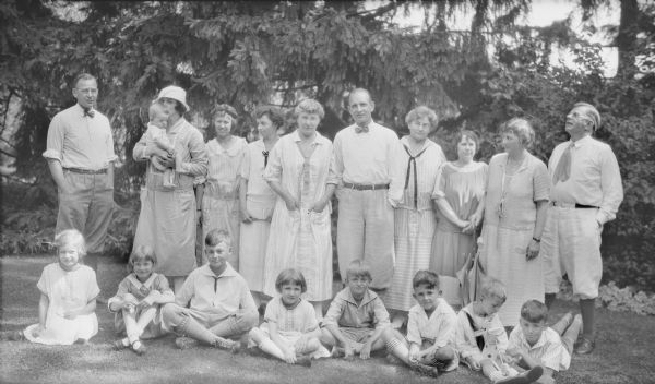 Several children of George and Henriette Brumder, with their spouses, children and grandchildren posing for a group portrait on the grounds of Villa Henrietta, the family summer estate at Pine Lake.