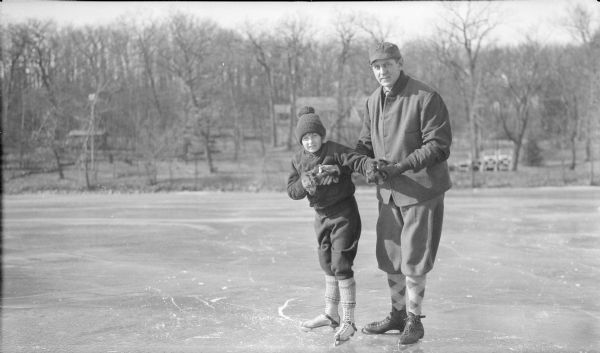 Herbert Paul Brumder posing with his daughter, Barbara, while skating on the ice of Pine Lake. The roof of their summer home, built in 1926, is in the background.  