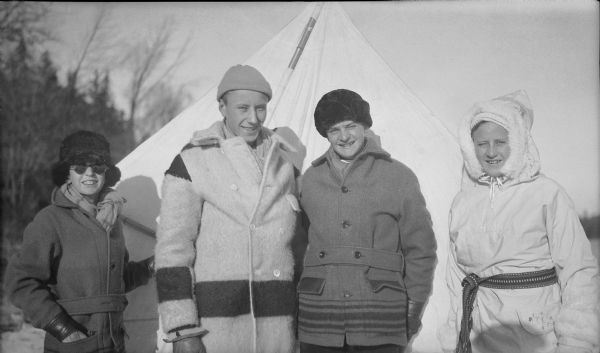 Herbert Paul Brumder, second from left, posing on frozen Pine Lake with his children, from left, Philip, Herbert E. and Barbara. All are wearing winter coats and hats, and Barbara has her hood up as well. Behind them is a large kite.