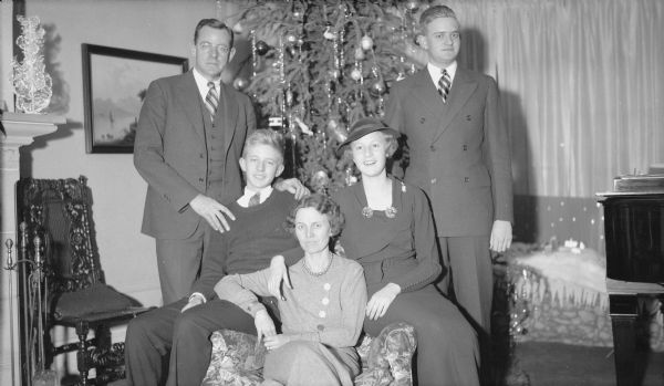 The Herbert P. Brumder family posing for a group portrait in front of the Christmas tree in the living room of their home at 2030 East Lafayette Place. The group includes, from left, Herbert Paul, Philip, Margaret Bouer (Mrs. Herbert P.), Barbara and Herbert Edmund Brumder.