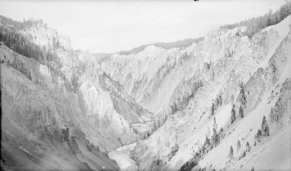 An elevated view of the Yellowstone River winding through a narrow, rhyolite-walled canyon.