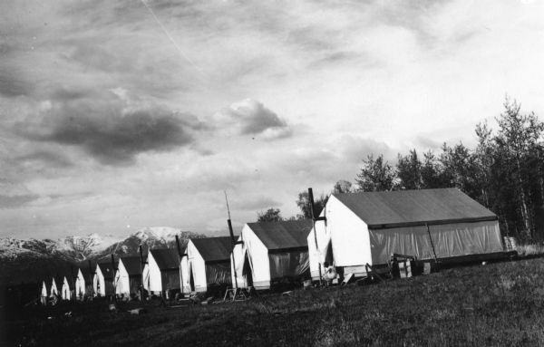 One of two images under the headline: "Wives of Alaskan Pioneers Kept Busy Sewing, Making Tent Homes Neat and Clean." Original caption reads: "... a row of neat tents in camp No. 8."
