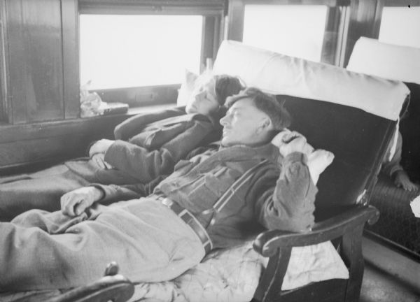 John Herman and his wife sleeping in their seats on a railroad car. Printed in <i>The Milwaukee Journal</i> with a caption that reads: "The train ride in day coaches from Wisconsin and Michigan farms to Seattle proved tedious for most of the pioneers who are now on their way by boat to Alaska to settle in the Matanuska valley. Shown here are John Herman of Plymouth, Wis., and his wife catching a few winks as the train rolled over western prairies." Caption with print reads: "Sleeping on train en route to Seattle."