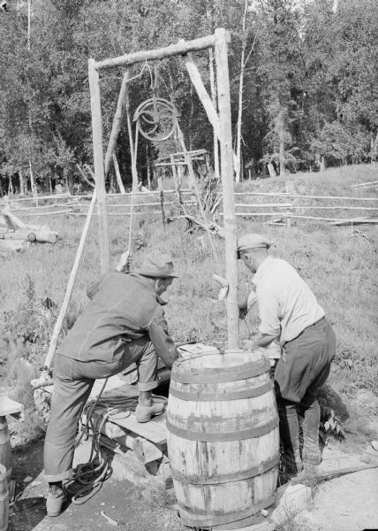 Two men working at a well at Camp 8.