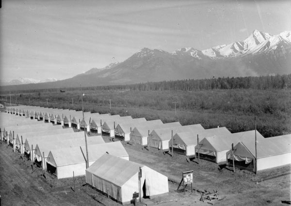 Elevated view of tent camp, with Chugach mountains in background.