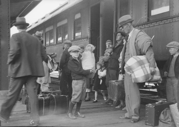People on railroad platform boarding a train.