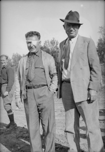 Caption with negative: "Rogers and Post a few minutes after landing." Another man is standing in the background on the left.