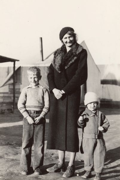 Original caption reads: "Mrs. Agnes Sandvik (and children) a leader in the colony, both in early protest and early and subsequent progress. Caption with negative reads: Mrs. I.M. Sandvik of Moose Lake, Minn., a leader in the colonist appeal to President Roosevelt for action, is shown with two of her six children, Lynn (left) and Peter."