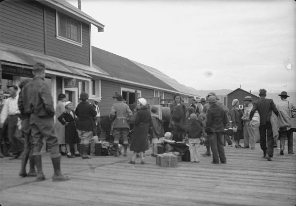 Original caption reads: "Families leaving from colony -- Shown on platform at Matanuska village, where caught train for Seward."