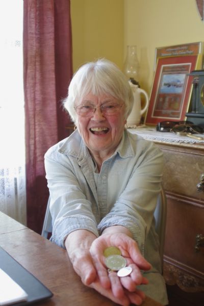 Gerry Keelingand holding cooperative tokens issued by the Alaska Rural Rehabilitation Corporation, the governing body of the Matanuska Valley Colony, founded in 1935. Colonists were required to use the tokens at the community's agricultural cooperative.