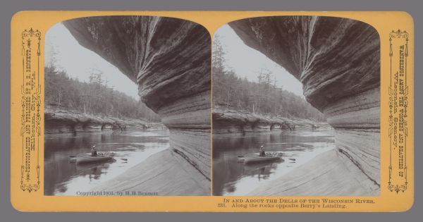 View from shoreline towards a man in a rowboat at Berry's Landing, along the rocks opposite. Caption at bottom: "In and About the Dells of the Wisconsin River. 233. Along the rocks opposite Berry's Landing." Text at right: "Wanderings Among the Wonders and Beauties of Wisconsin Scenery."
