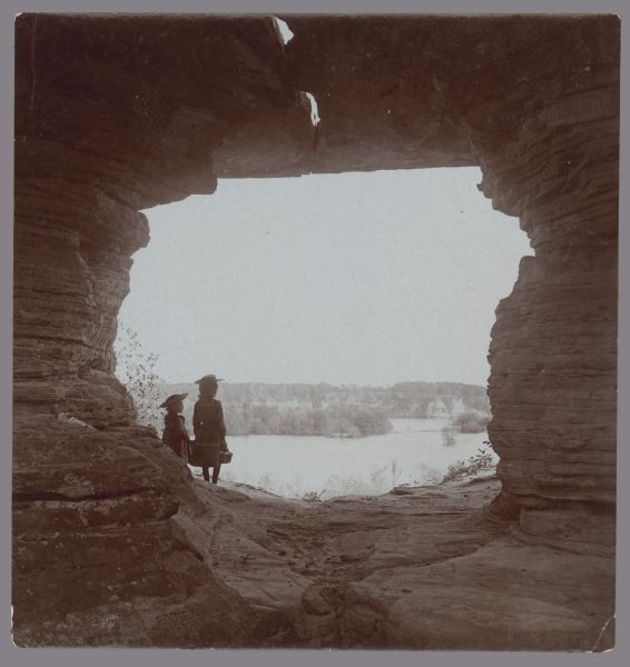 View through rock formation towards Ruth and Miriam Bennett at Luncheon Hall. They are looking out toward Witches' Gulch.