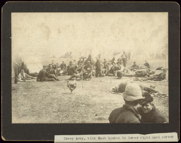 Group of men gathered outdoors around a rooster. Tents are in the background. Caption reads: "Coxey Army, with Jack London in lower right hand corner."