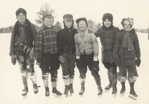 Group of children wearing ice skates standing together on Trout Lake.