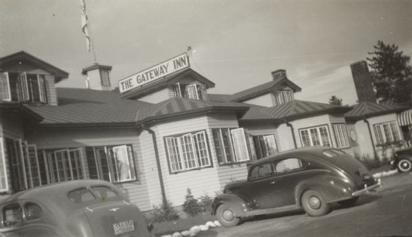View of The Gateway Inn, with automobiles parked on front.
