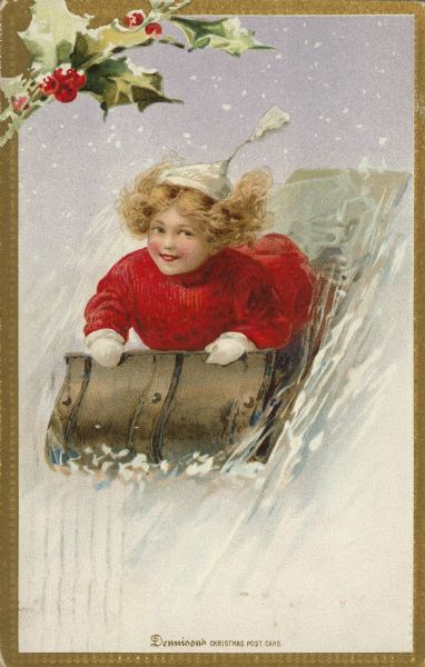 Christmas postcard of a child on a toboggan. She is wearing a red coat and white mittens, also a white hat with a tassel. Her hair is flying in the wind. The image is in a metallic gold embossed frame with holly in the upper left corner. Text at bottom reads: "Dennison's Christmas Post Card." Chromolithograph and embossed.