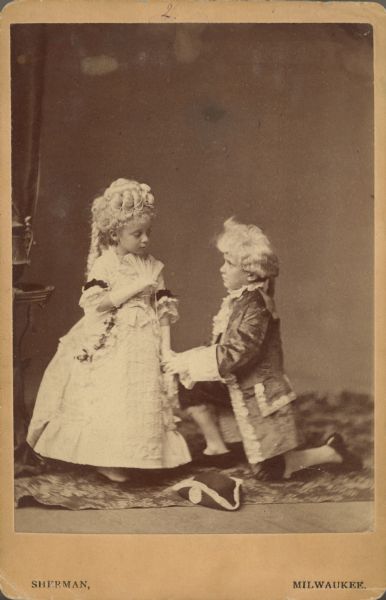 Carte-de-visite portrait of two children, Carol Sanderson and Paul D. Carpenter, in costume as Martha and George Washington. The reverse of the cabinet card includes the poem "Yielding."