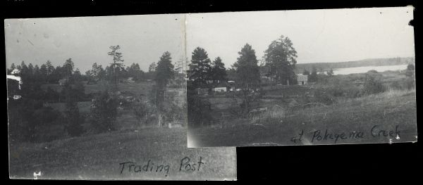 Slightly elevated view of several buildings among scattered trees along a body of water.