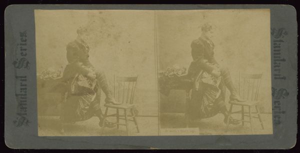 Stereographic image of a woman adjusting her stocking. Below the right image is the caption: "It won't Stay up." Stereograph reads "Standard Series" on either side.